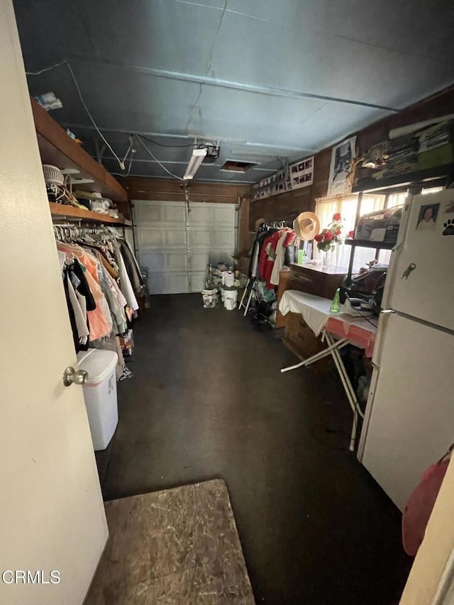 garage featuring a garage door opener and white refrigerator