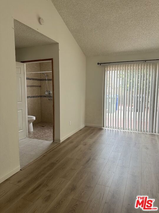 unfurnished bedroom with hardwood / wood-style flooring and a textured ceiling