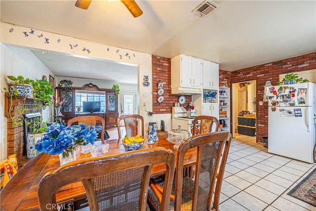 dining room with ceiling fan, light tile patterned floors, and brick wall