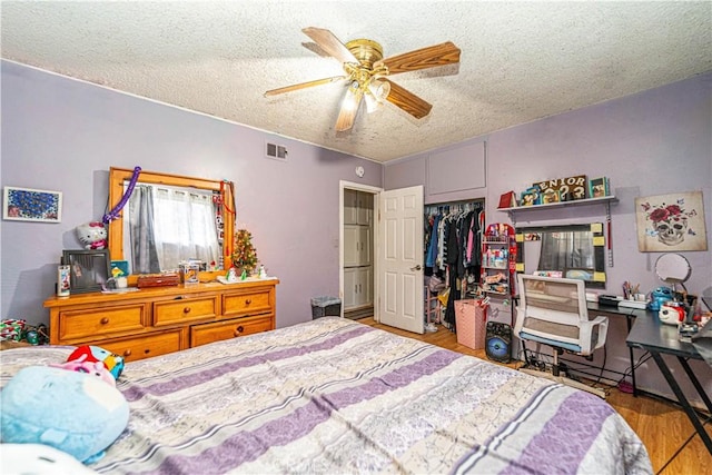 bedroom featuring ceiling fan, a textured ceiling, hardwood / wood-style flooring, and a closet