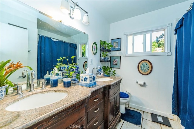 bathroom with toilet, vanity, and tile patterned flooring