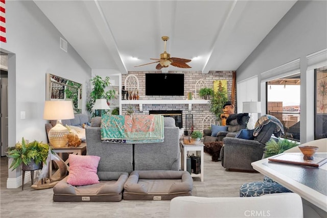 living room featuring ceiling fan, hardwood / wood-style floors, and a fireplace