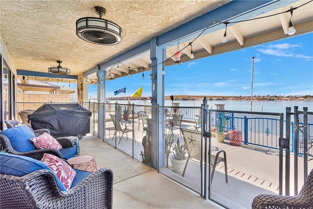 view of patio / terrace featuring a water view, a balcony, and a grill