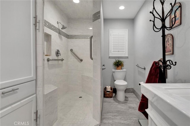 bathroom featuring a shower with shower door, hardwood / wood-style flooring, toilet, and vanity