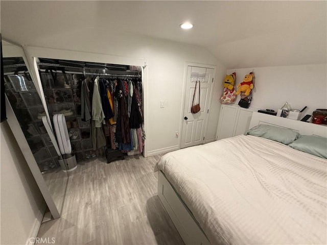 bedroom with light hardwood / wood-style flooring and vaulted ceiling