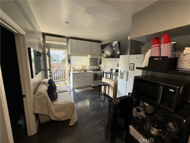 kitchen featuring a wall unit AC, sink, white appliances, white cabinetry, and dark hardwood / wood-style flooring