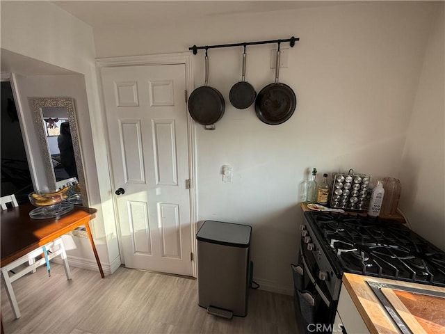 kitchen with butcher block countertops, light hardwood / wood-style flooring, and black gas range