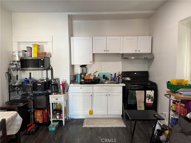 kitchen with white cabinets, dark hardwood / wood-style flooring, sink, and black gas range