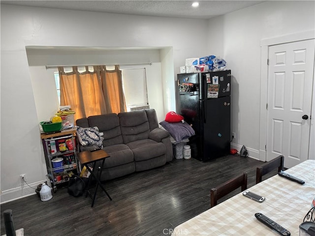 living room featuring dark wood-type flooring and a textured ceiling