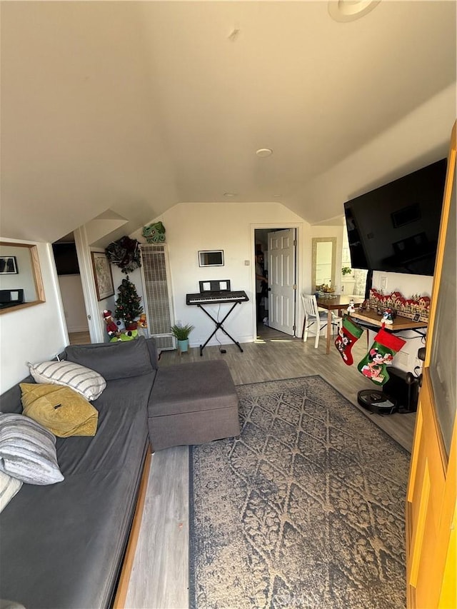 living room with vaulted ceiling and hardwood / wood-style flooring