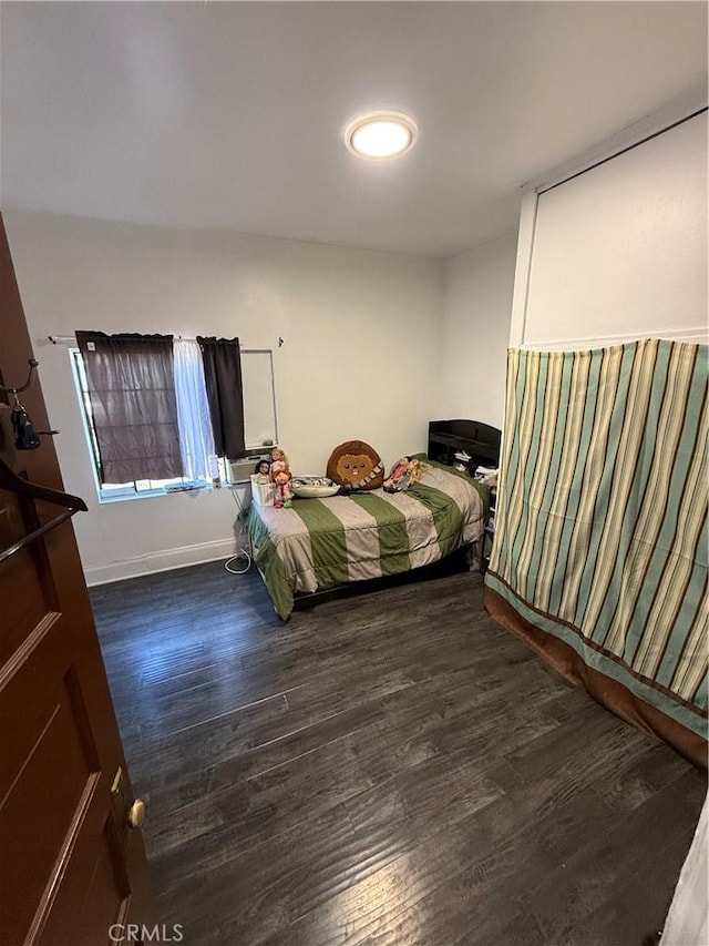 bedroom with dark hardwood / wood-style floors