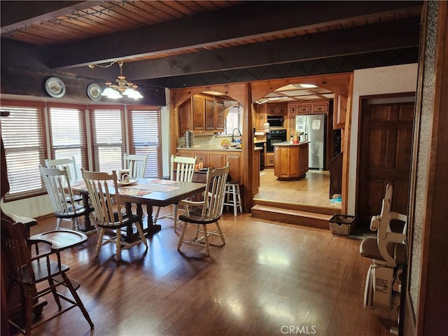 dining room with wooden ceiling, a notable chandelier, beamed ceiling, and light wood-type flooring