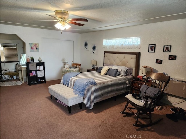 bedroom featuring ceiling fan, carpet, and a textured ceiling