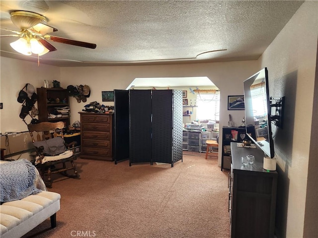 carpeted bedroom with a textured ceiling and ceiling fan