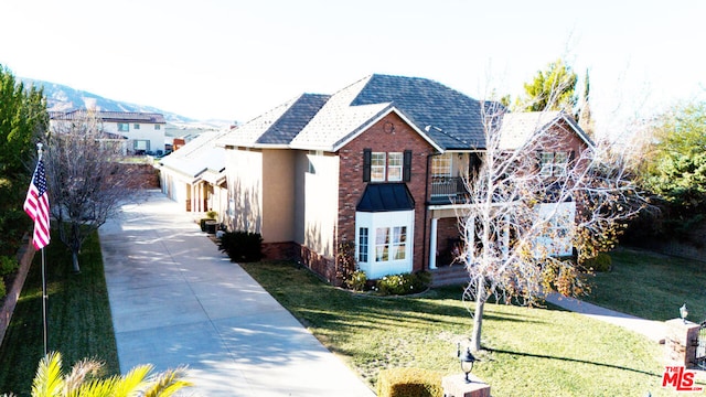 view of front facade featuring a front lawn and a mountain view