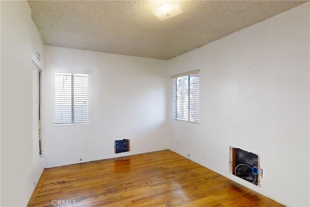 empty room with a textured ceiling and hardwood / wood-style floors