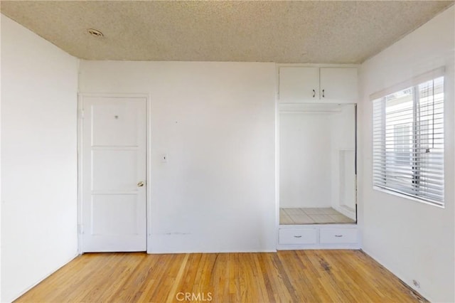 interior space with a textured ceiling and light hardwood / wood-style flooring