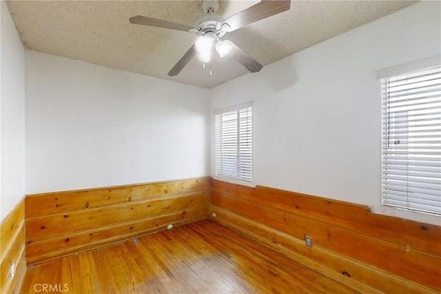 unfurnished room with a textured ceiling, ceiling fan, and hardwood / wood-style floors