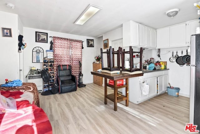 kitchen with light hardwood / wood-style floors and white cabinets