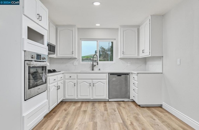 kitchen featuring sink, white cabinetry, appliances with stainless steel finishes, and light wood-type flooring