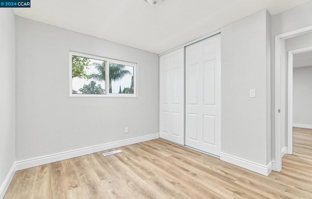 unfurnished bedroom with a closet and light hardwood / wood-style flooring