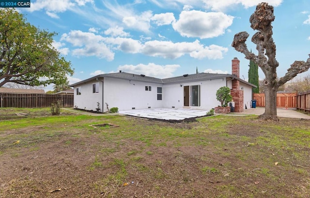 back of house featuring a patio area and a lawn