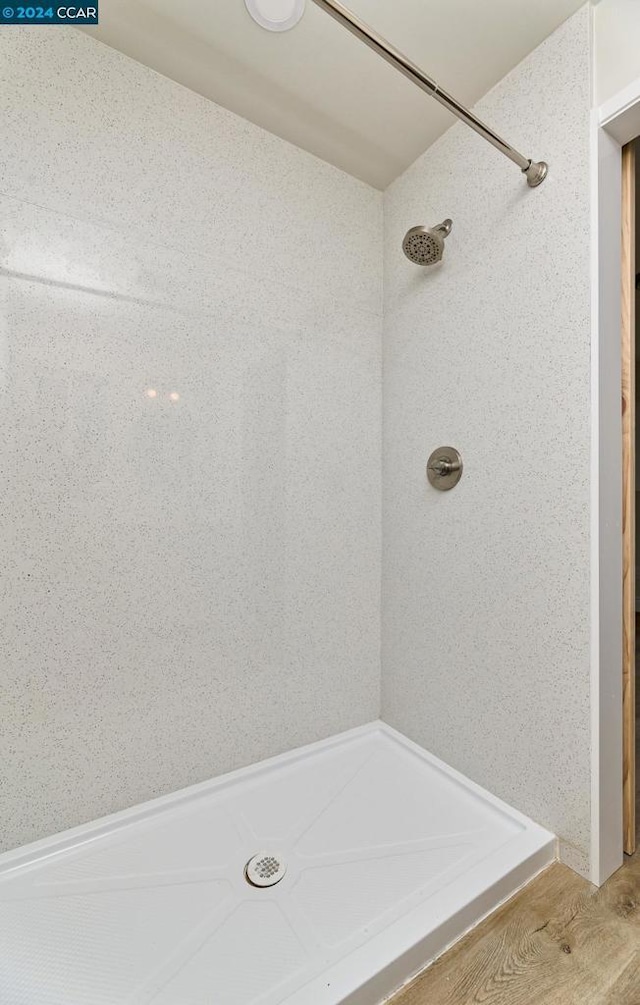 bathroom with hardwood / wood-style flooring and a shower