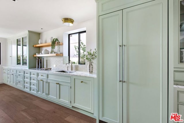 interior space featuring a healthy amount of sunlight, wood-type flooring, tasteful backsplash, and sink