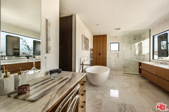 bathroom featuring separate shower and tub and vanity