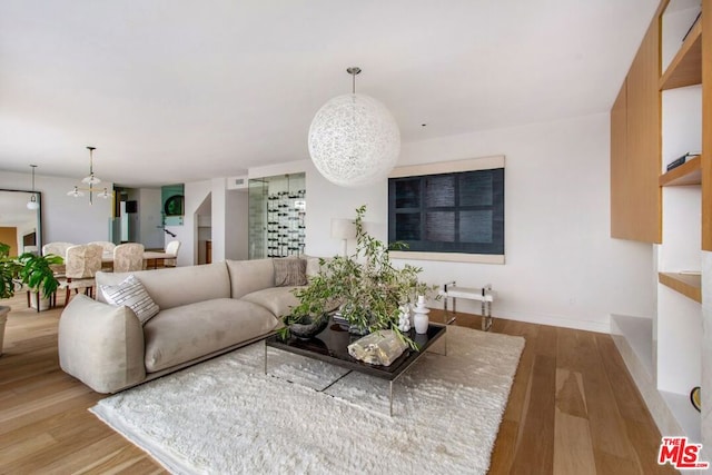 living room with an inviting chandelier and wood-type flooring