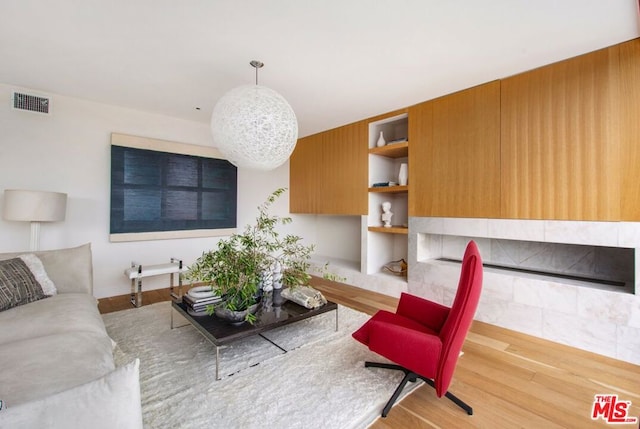 living room featuring built in shelves and hardwood / wood-style flooring