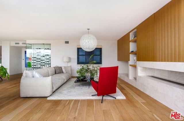 living room with built in features and light hardwood / wood-style floors