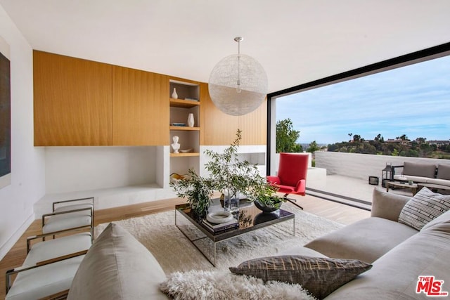 living room featuring built in shelves and hardwood / wood-style floors