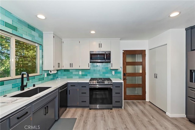 kitchen featuring gray cabinets, sink, white cabinetry, light hardwood / wood-style flooring, and appliances with stainless steel finishes