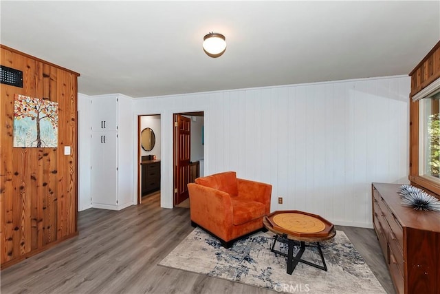 sitting room featuring light hardwood / wood-style floors and wood walls