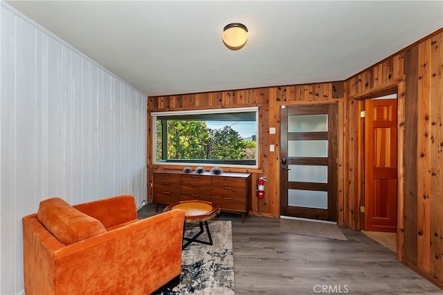 living area with hardwood / wood-style floors and wooden walls
