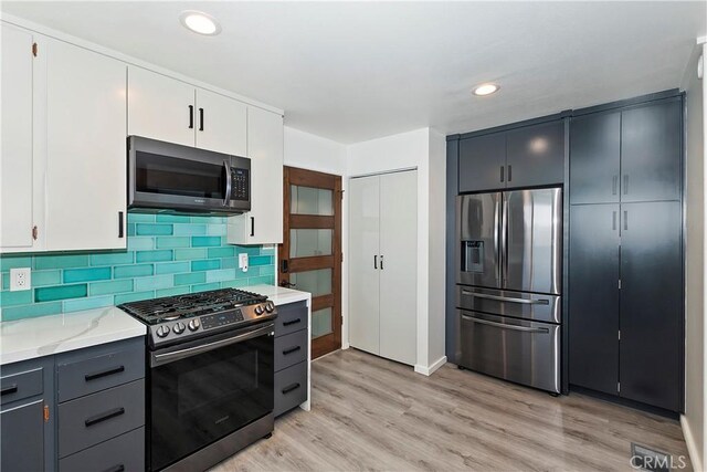 762 Zurich Dr, Lake Arrowhead, CA 92352 - kitchen featuring appliances with stainless steel finishes, light wood-style floors, tasteful backsplash, recessed lighting, and white cabinets