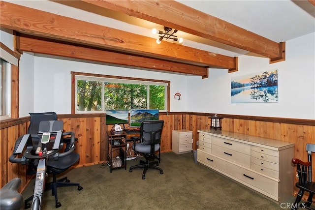 carpeted home office with wooden walls and beamed ceiling