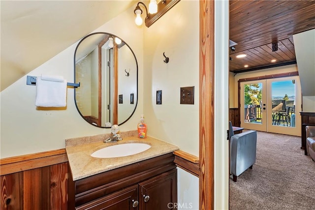 bathroom with wood ceiling, vanity, french doors, and wooden walls