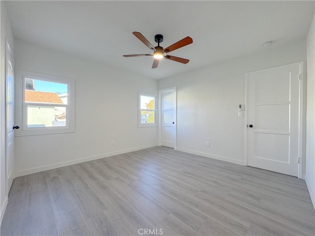 empty room with ceiling fan and light wood-type flooring