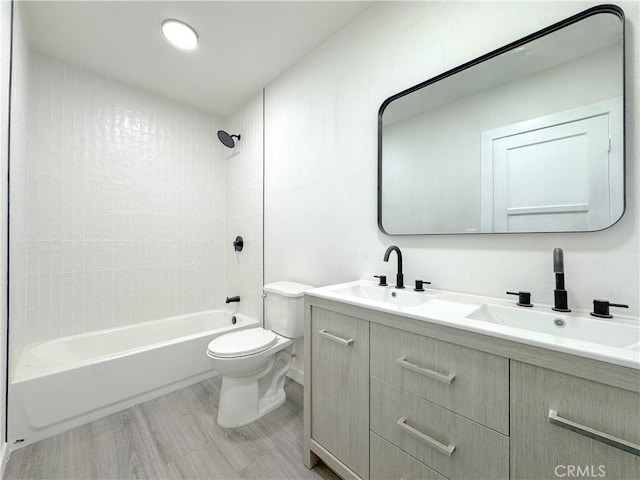 full bathroom with toilet, tiled shower / bath, vanity, and hardwood / wood-style floors