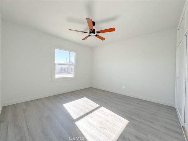 spare room featuring light wood-type flooring and ceiling fan