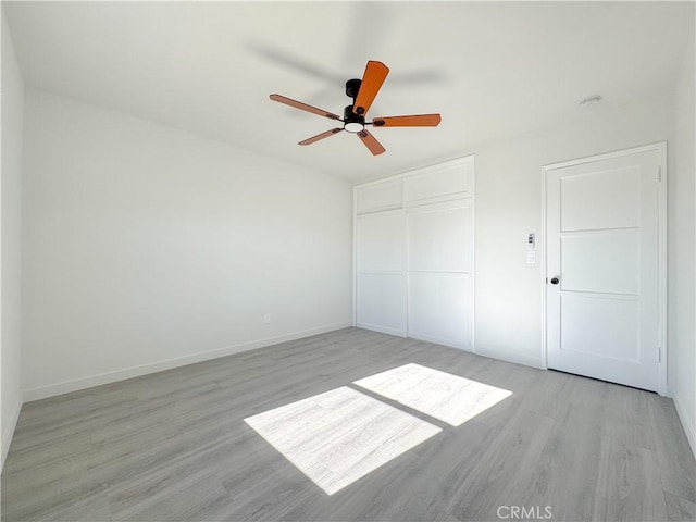 unfurnished bedroom with ceiling fan, a closet, and light hardwood / wood-style floors