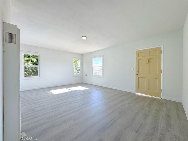 spare room with a healthy amount of sunlight and light wood-type flooring