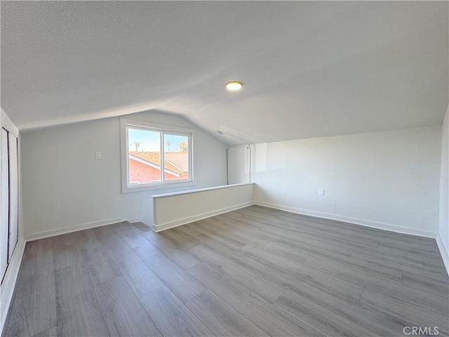 bonus room featuring vaulted ceiling and hardwood / wood-style floors