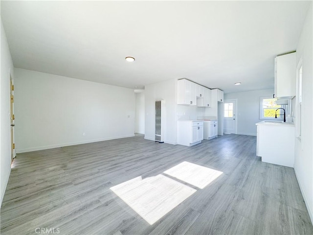 unfurnished living room featuring light hardwood / wood-style floors and sink