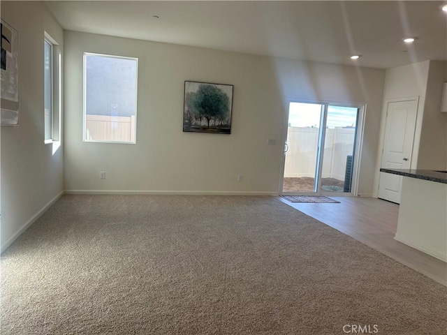 unfurnished living room featuring light colored carpet