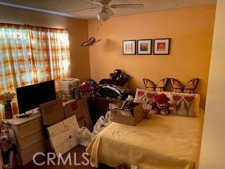 carpeted bedroom with ceiling fan and a textured ceiling