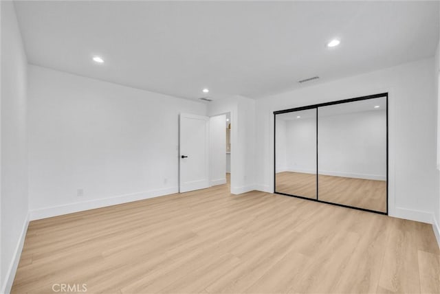 unfurnished bedroom featuring light wood-type flooring and a closet