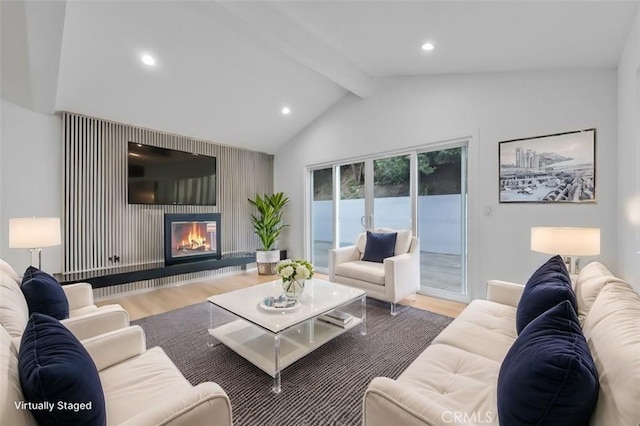 living room featuring a large fireplace, hardwood / wood-style floors, and lofted ceiling with beams